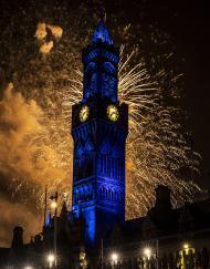 Fireworks explode behind clock tower of Bradford City Hall