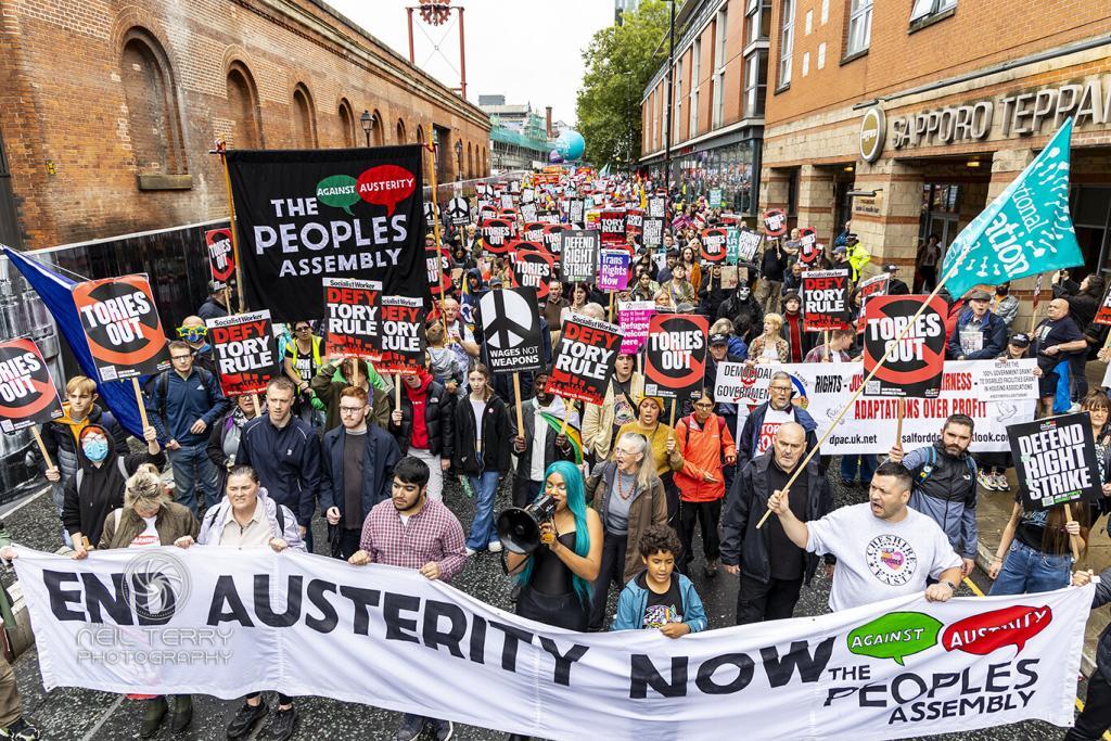 Large crowd gathered behind banner reading end austerity now