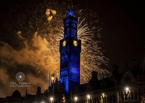 Fireworks explode behind clock tower of Bradford City Hall